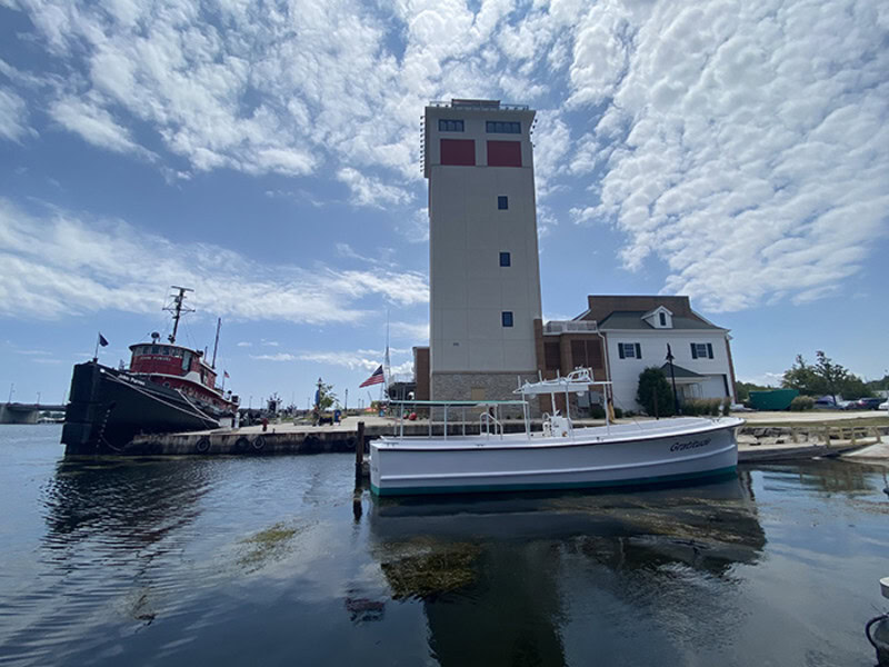 boat on water by lighthouse